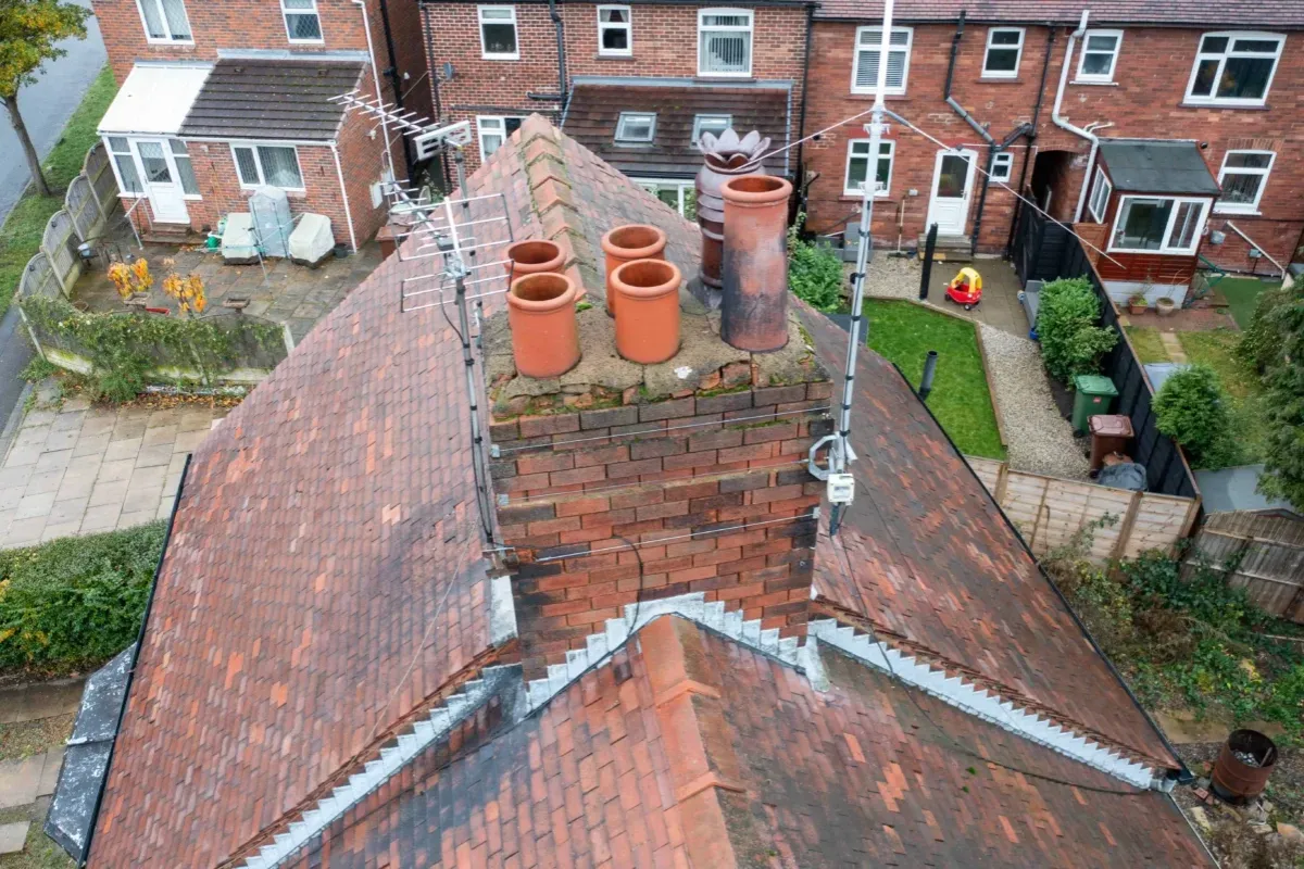 Drone view looking down on a tiled roof and chimney