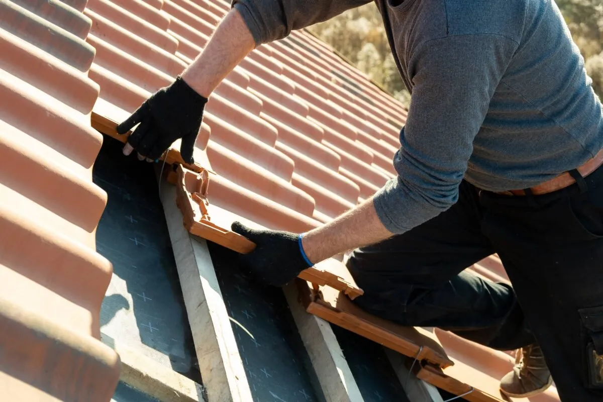 Roofer fitting new roof tiles