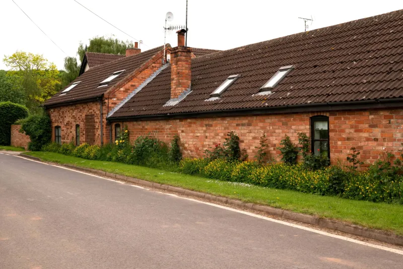 Pitched tiled roof on a brick cottage